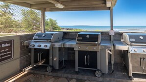 An outdoor grill station with multiple grills and a view of the ocean. - Recent remodel - Large 1BR w/ ocean view and walk to excellent beaches/eateries (Kihei)