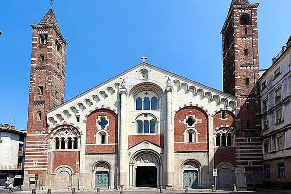 A historic church with two prominent towers and a central facade with arched windows and a large entrance.