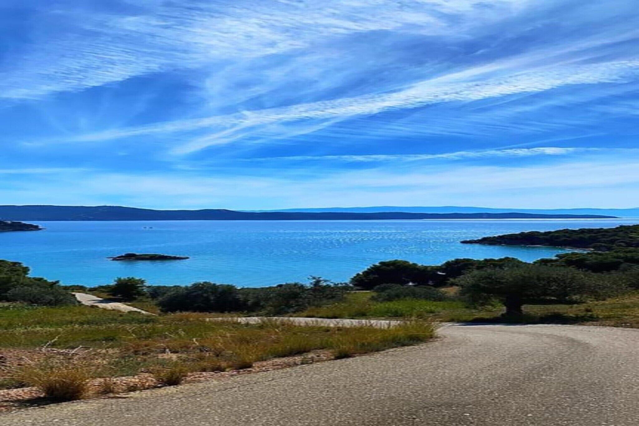 Une route côtière, avec un ciel dégagé et une mer calme.