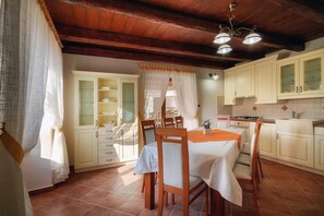 Enjoy meals in this kitchen with a dining table and chairs, sink, and tiled backsplash.