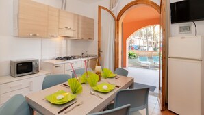 A modern kitchen with wooden cabinets, a gas stove, a microwave, and a refrigerator.