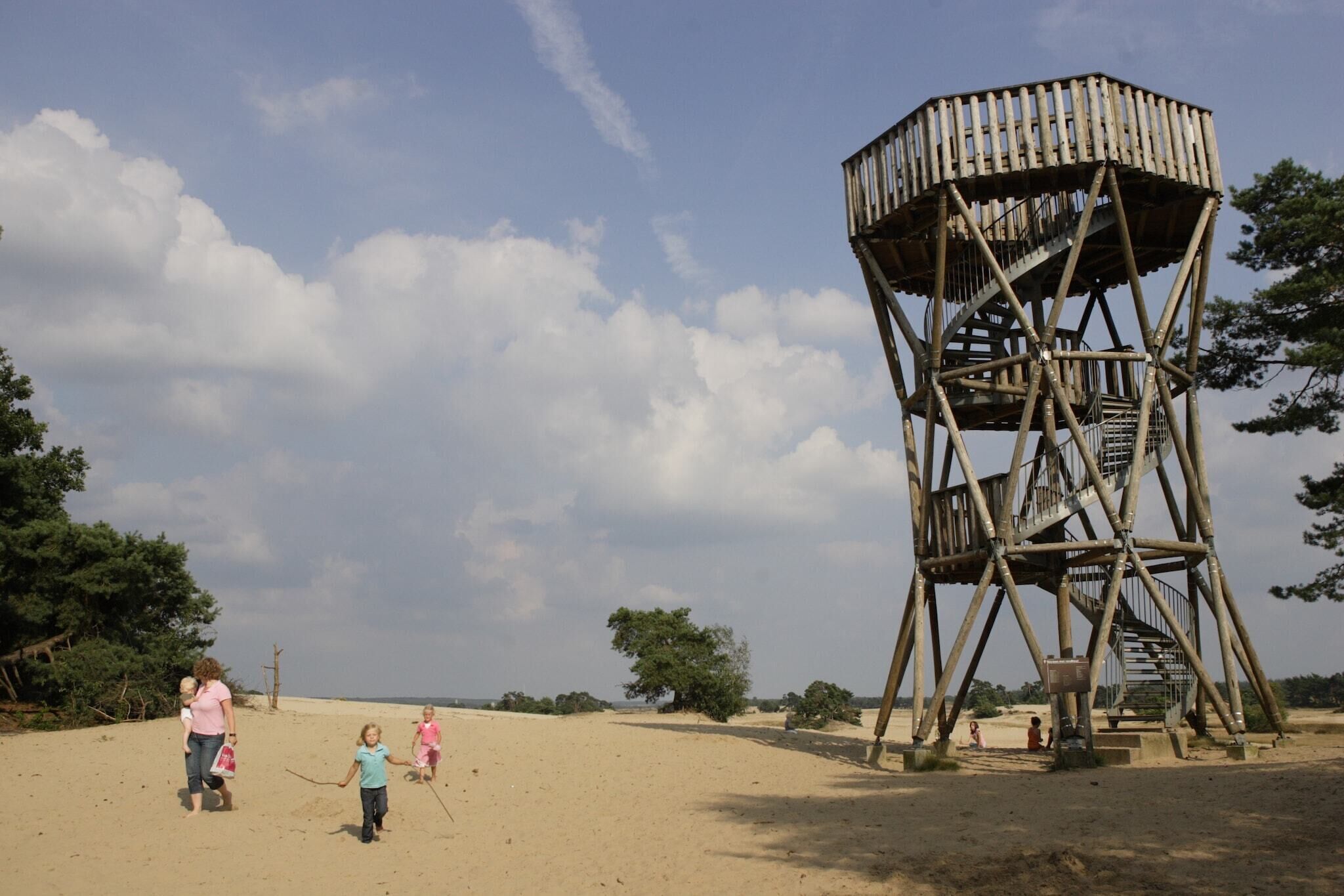 Una playa arenosa con una torre de madera para observar.