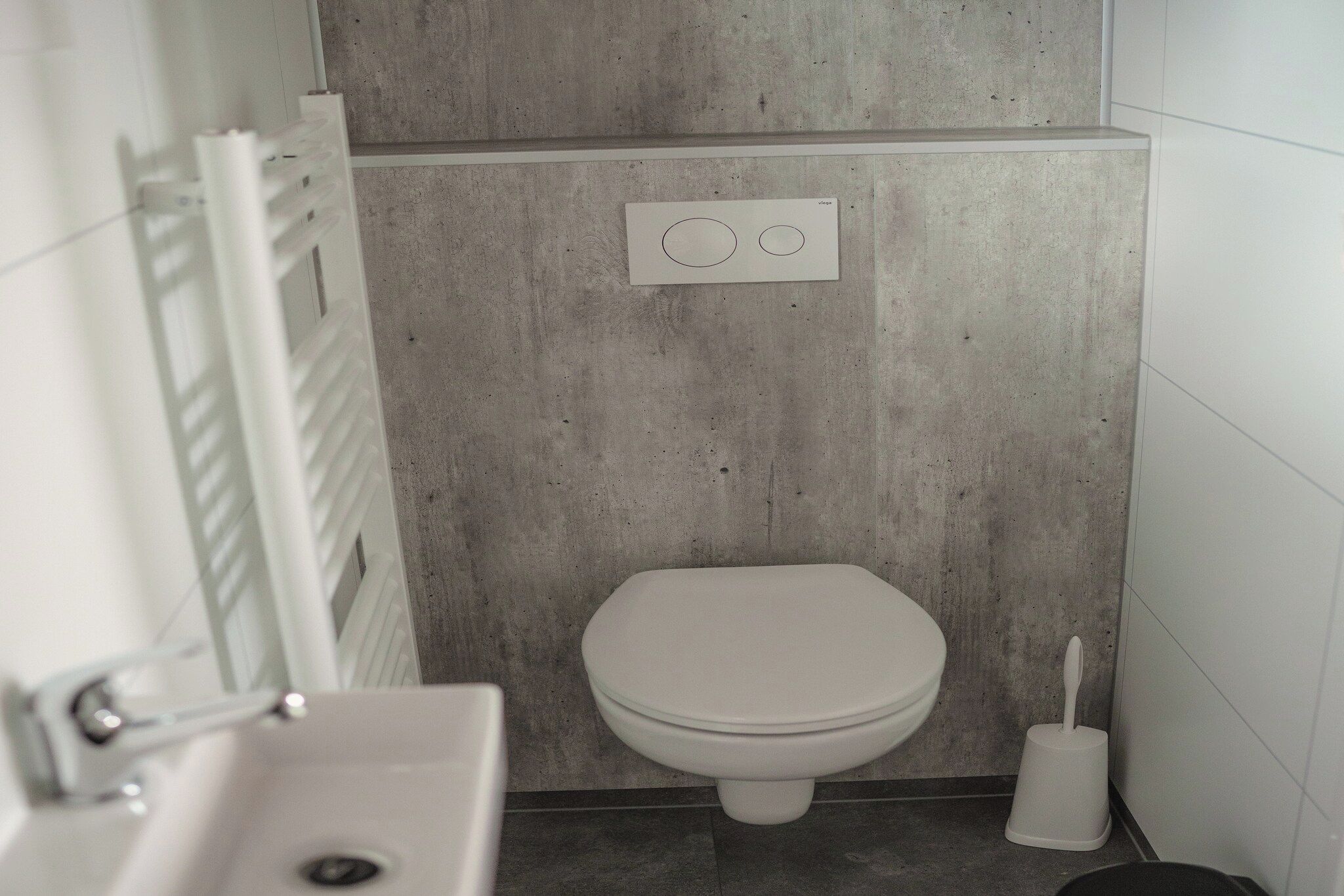 Ein Badezimmer mit Toilette, Bidet und Wandspülung.
