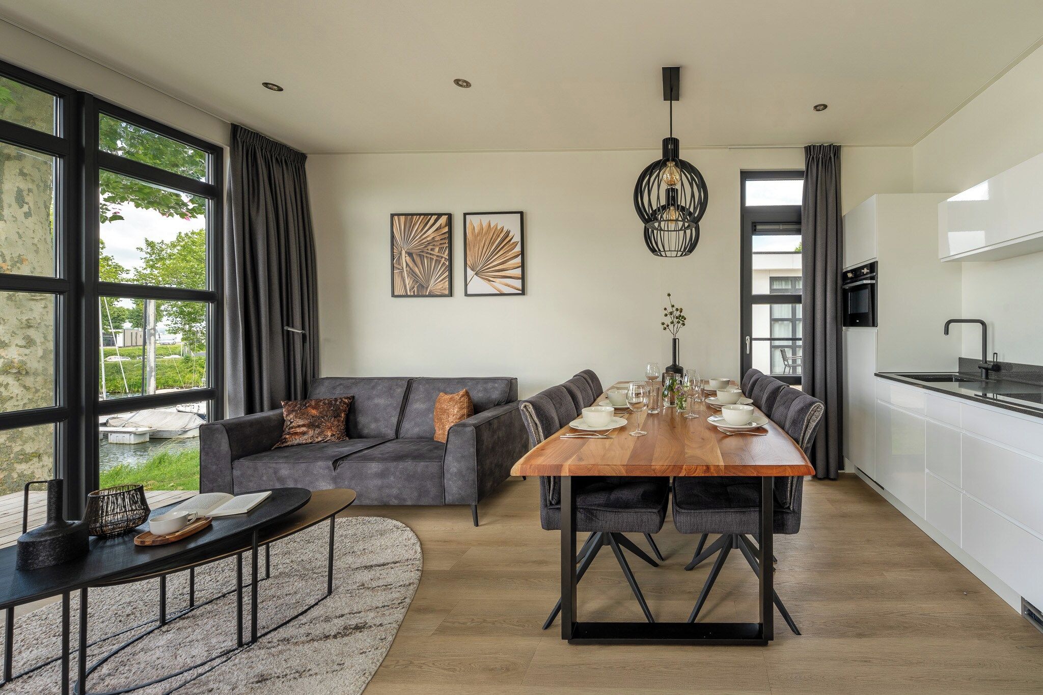 Un espacio habitable moderno con comedor, sofá y cocina.