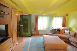 Relax in this inviting living room with a TV, decorative cabinet, and plush sofa.