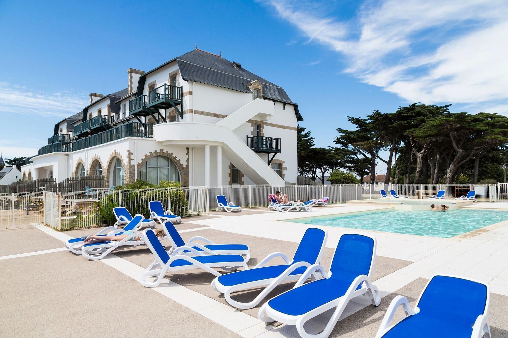 A poolside area with lounge chairs and a swimming pool.
