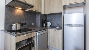 Eine moderne Küche mit eingebautem Ofen, einer Kaffeemaschine und einem Edelstahl-Kühlschrank.