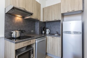 A modern kitchen with a built-in oven, a coffee maker, and a stainless steel refrigerator. - Apartment in Côte Sauvage near La Baule Bay (Batz sur Mer)