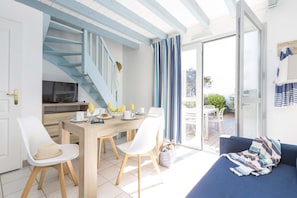 A modern kitchen with a dining area, a staircase, and a view through a glass door to an outdoor space. - Apartment in Côte Sauvage near La Baule Bay (Batz sur Mer)