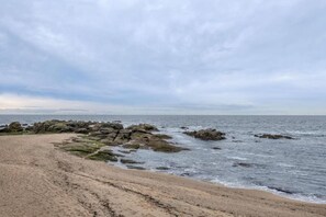 A coastal beach with rocky formations and a sandy shore.