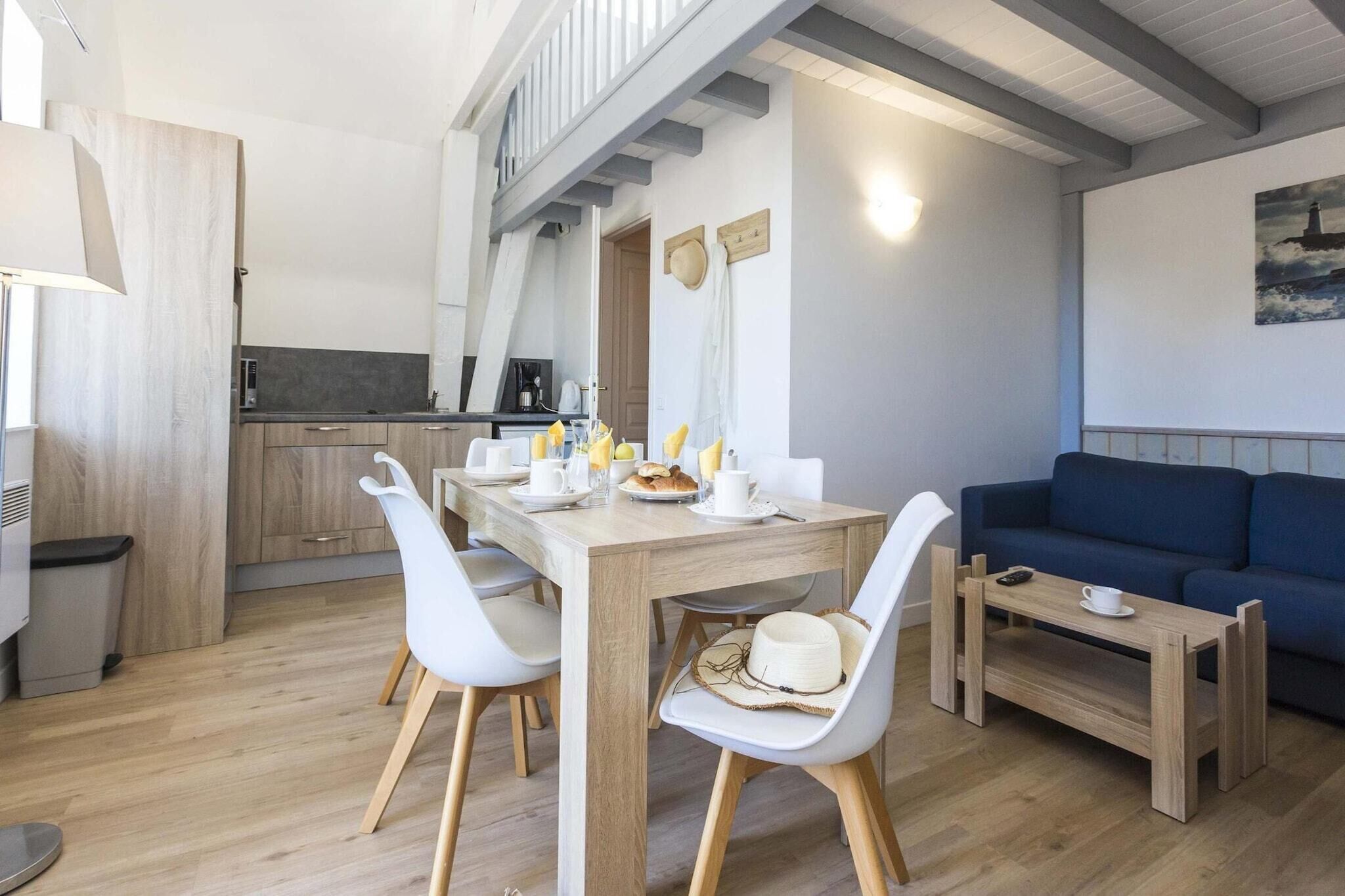 Un espacio moderno para vivir con comedor, cocina y un sofá azul.
