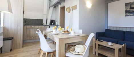 Un espacio moderno para vivir con comedor, cocina y un sofá azul.