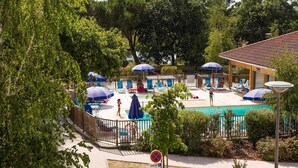 A pool area with lounge chairs and umbrellas, a sign indicating no parking, and a disabled access sign. - Maisonette by Hourtin-Carcans Lake (Hourtin)