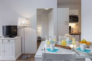 A modern kitchen with a microwave, a coffee maker, and a dining area with a table set for breakfast.