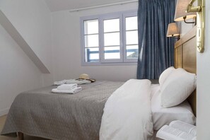 Ein Schlafzimmer mit einem Bett, einem Fenster und einem Nachttisch.