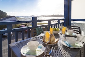Ein Frühstückstisch mit Blick auf Strand und Meer.