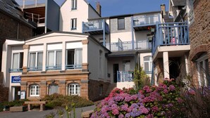 A multi-story building with a sign for 'Oasis Accommodations' indicating a hotel or lodging facility. - Apartment in Trégastel near Renote Island (Trégastel)
