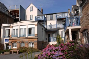 A multi-story building with a sign for 'Oasis Accommodations' indicating a hotel or lodging facility. - Apartment in Trégastel near Renote Island (Trégastel)