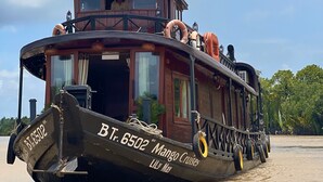 Un'imponente battello a vapore di legno con la scritta "Mango Cruises" e il numero "BT 6502" sul fianco, che galleggia sull'acqua.