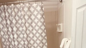 A bathroom with a patterned shower curtain, a toilet, a bathtub, and a towel rack. - North Star Place Apt 8 (Fairbanks)