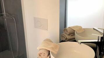 Een haardroger, handdoeken, zeep, toiletpapier