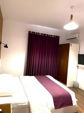 A hotel room with a bed, a wardrobe, a television, and an air conditioning unit. - Hotel Sidi (Tirana)
