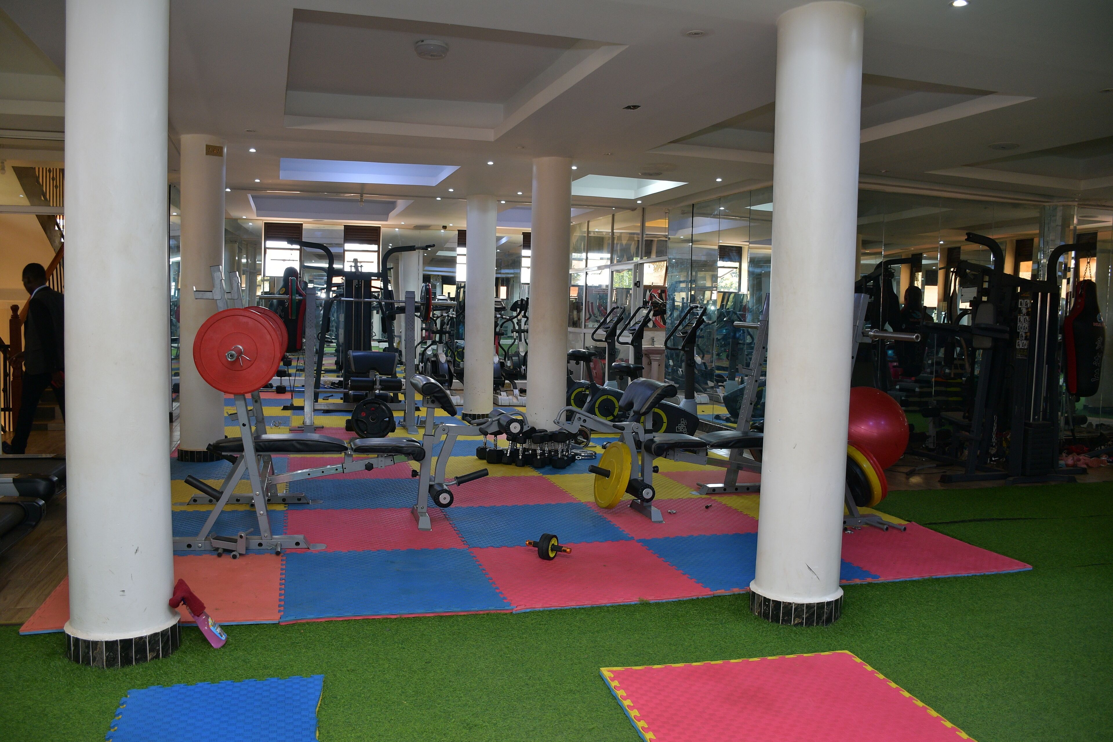 A gym with various exercise equipment, including treadmills, weight machines, and free weights.