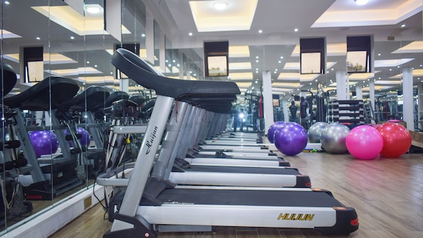 A gym with treadmills, exercise balls, and mirrors.
