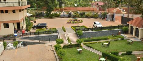 A courtyard with a paved walkway, seating areas, and a small fountain.
