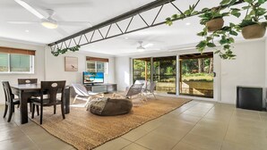 Un grand espace de vie comprenant une table à manger, des chaises, un canapé et un téléviseur.