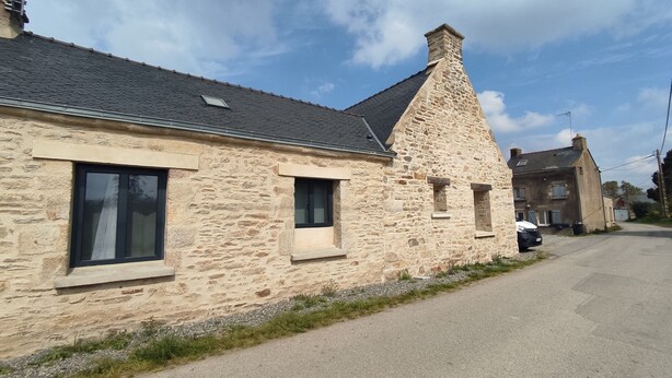 A stone building with a sloped roof, multiple windows, and a gravel driveway. - Cosy Maison Familiale 10 Personnes (Péaule)