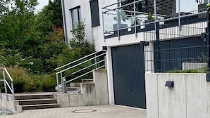 En modern byggnad med en fasad av betong, ett staket av metall och en mur av sten.