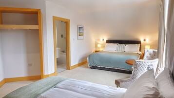 Een hotelkamer met een bed, een stoel, een nachtkastje en een kledingkast.