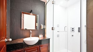 A modern bathroom with a large mirror, a white sink, and a glass-enclosed shower. - Huyen Homestay (Ho Chi Minh City)