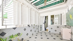 A room with a tiled floor, a white cabinet, and a door leading to another room. - Huyen Homestay (Ho Chi Minh City)