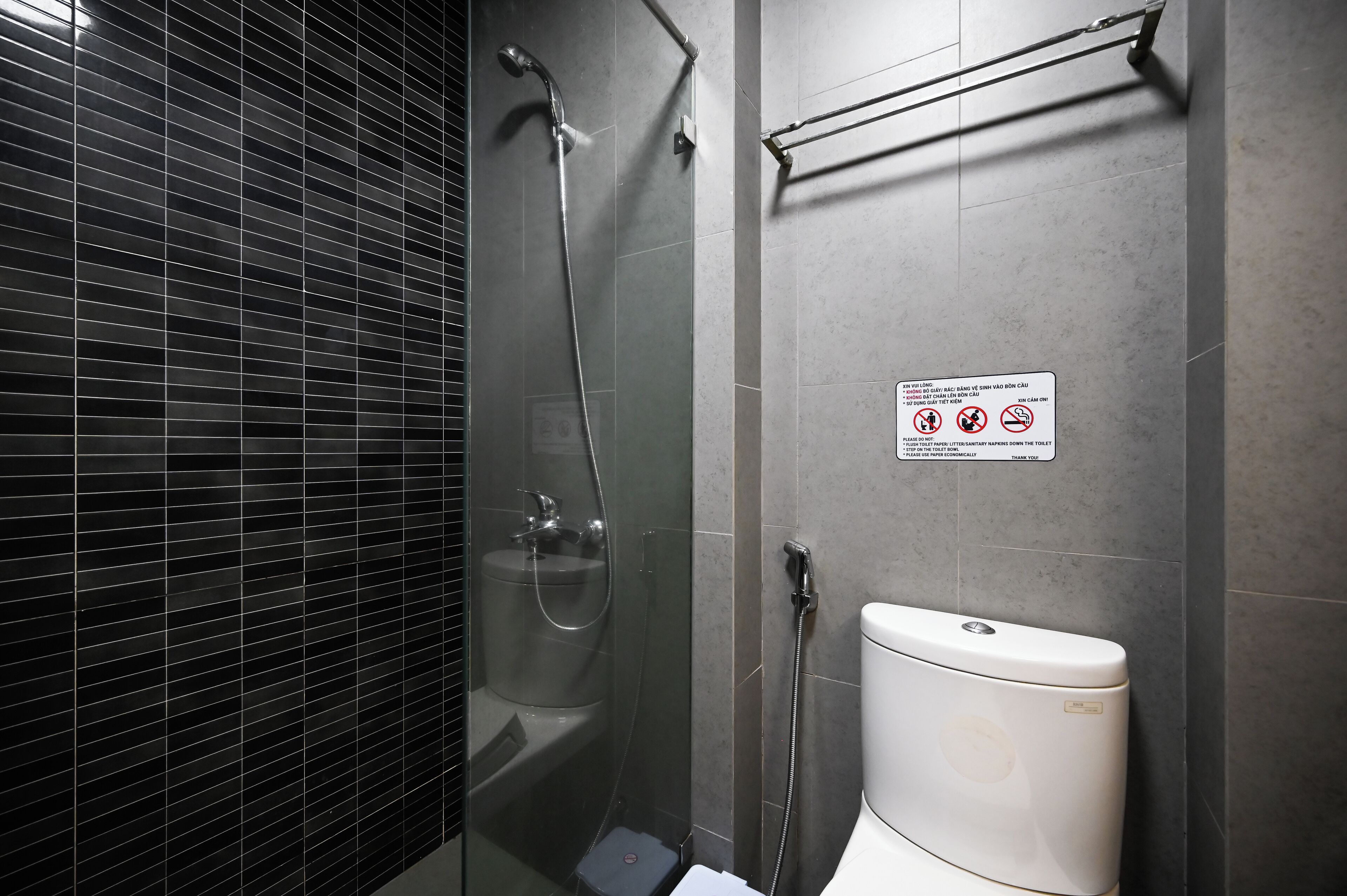 Ein modernes Badezimmer mit einer einteiligen Duschkabine, Toilette und Handtuchhalter.