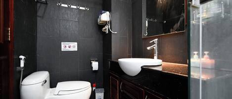 A modern bathroom with a toilet, bidet, and sink.