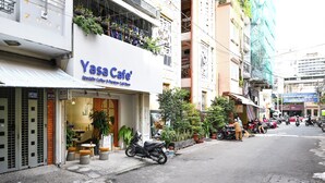 A storefront with a sign reading "Yasa Cafe" and a scooter parked outside. - Huyen Homestay (Ho Chi Minh City)