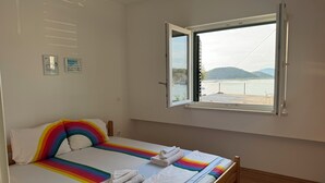 Ein Schlafzimmer mit einem Bett, einem Fenster mit freier Aussicht und einer Deckenleuchte.