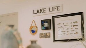 Eine Wand mit der Aufschrift "LAKE LIFE" und einer Illustration eines gerahmten Fisches.