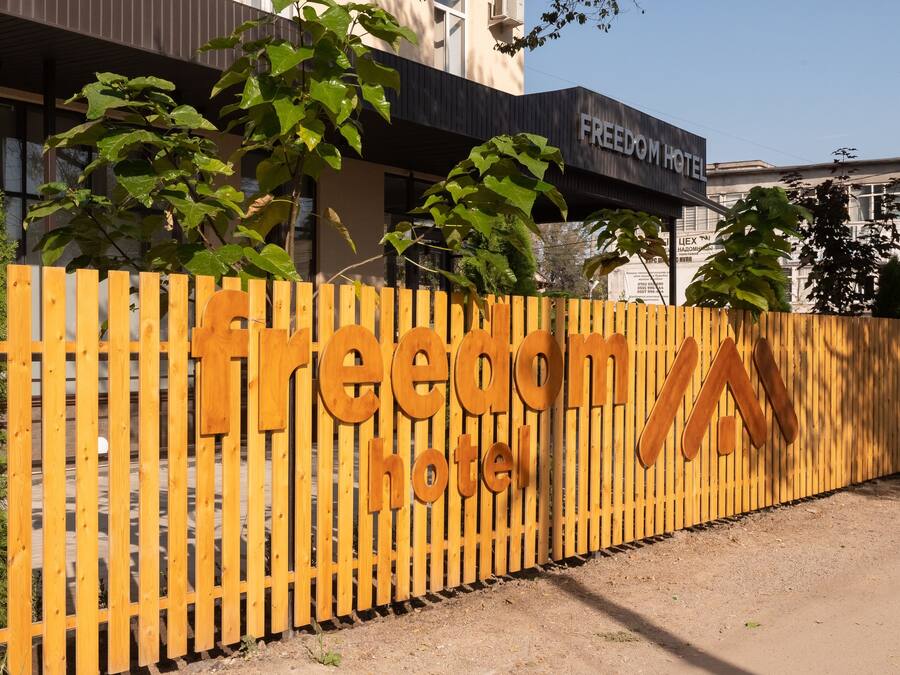 Een houten hek met het bord van Freedom Hotel.