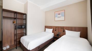 A hotel room with two beds, a wardrobe, a microwave, a phone, and a painting on the wall.