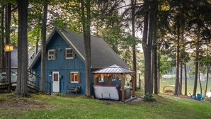 Una casa azul con un porche cubierto y un jacuzzi.