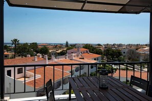 A balcony with a view of a coastal town, featuring terracotta-roofed buildings and a clear sky. - Comfy Apt. w/ View – Lagos (Lagos)