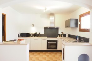 A modern kitchen with white cabinets, a built-in oven, and a window above the sink. - House in Vaison-la-Romaine with Pool (Vaison-la-Romaine)