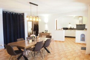 A modern kitchen with a dining area, a small island, and a large mirror.