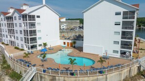 Un hotel con zona de piscina, varios balcones y vistas al agua.