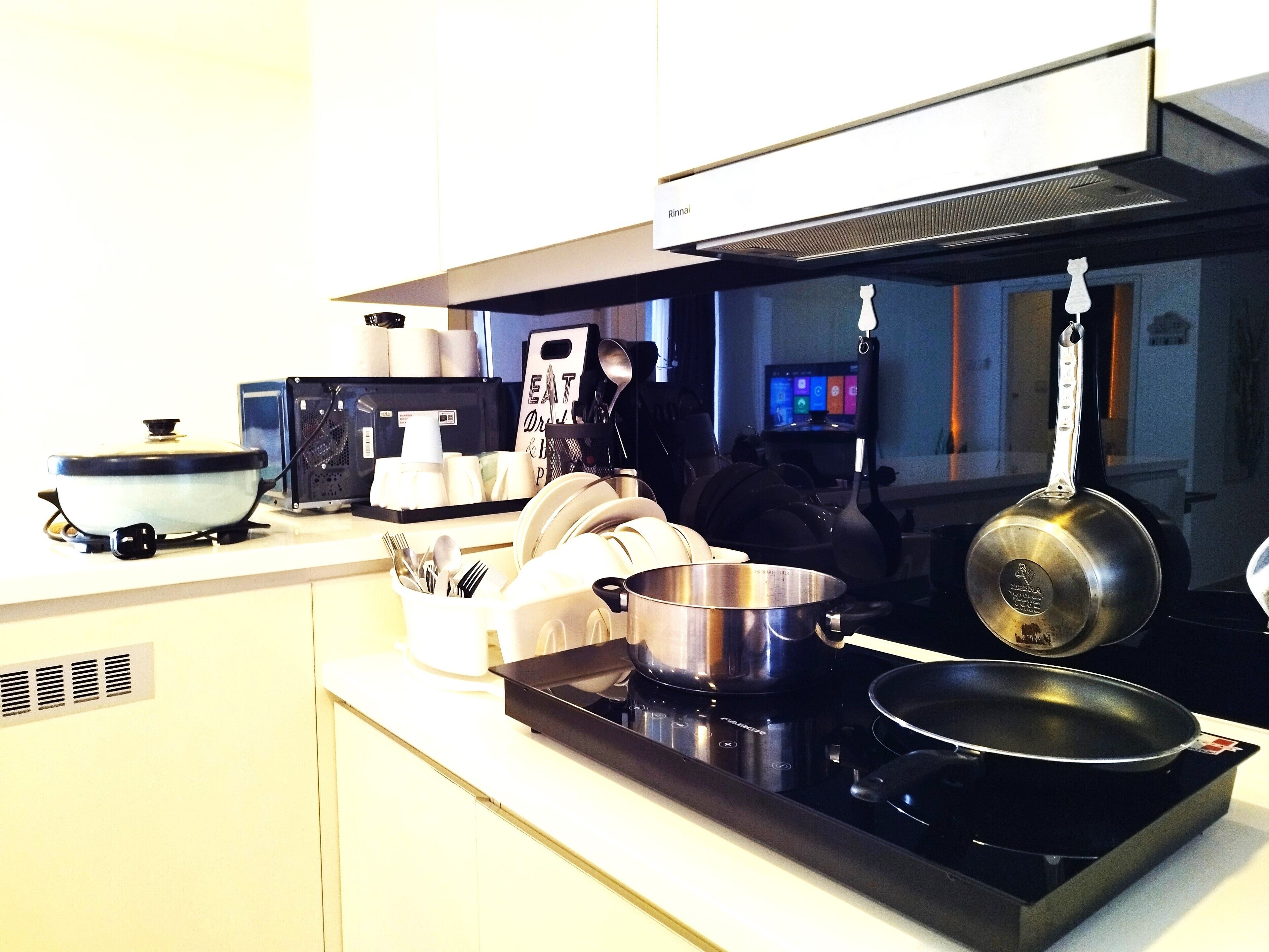A kitchen with a stove, pots, and a microwave.