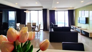 Ein modernes Hotelzimmer mit Essbereich, einer Couch und einem Fernseher.