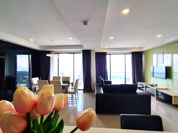 A modern hotel room with a dining area, a sofa, and a TV. - GENTING FoggyCold StayCation AT Ion Delemen By HAPYHOME (Genting Highlands)